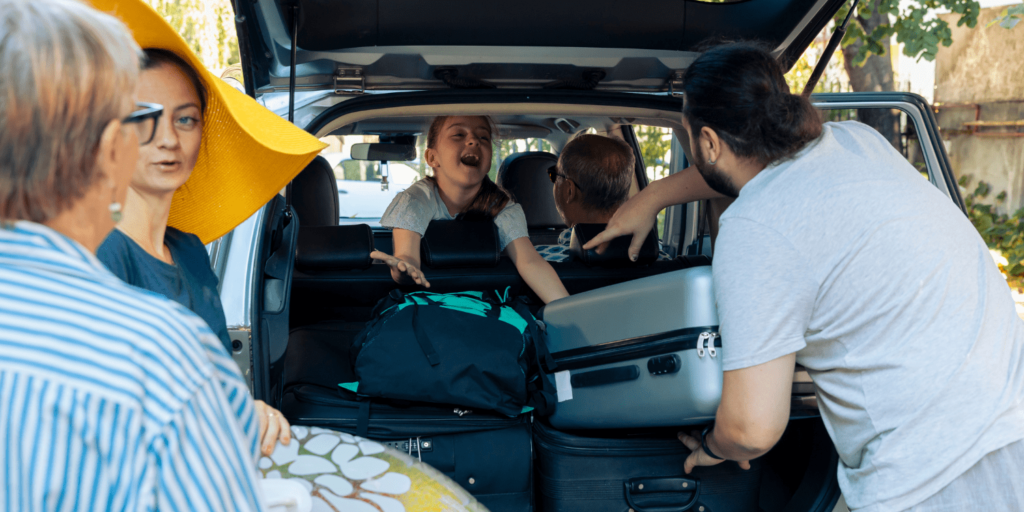 Familia organizando sus maletas en el coche para viajar en verano